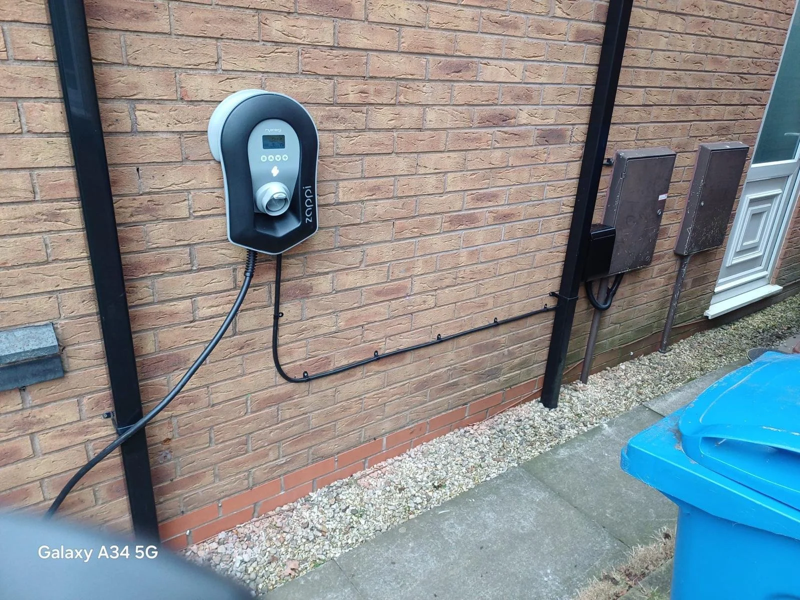 Clean external galvanized conduit routing to a newly installed Zappi charger unit.